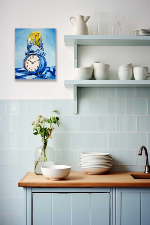 Two budgerigars huddle together on a vintage blue alarm clock in this tender and joyful oil painting. By Jess King Artist