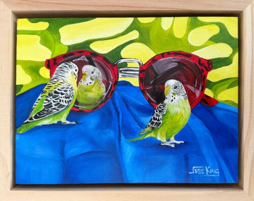 What a Pretty Boy" is an original oil painting by Australian artist Jess King, depicting two budgerigars with a pair of red tortoiseshell vintage sunglasses against a bold green leaf background.